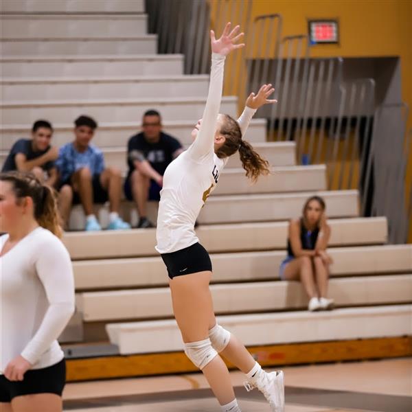 Girls Volleyball player jumping for ball